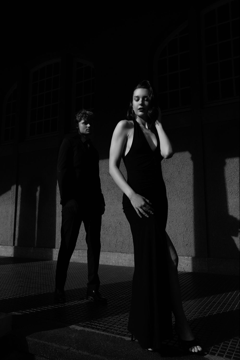 Dark atmospheric photograph of figures in shadows on textured floor.