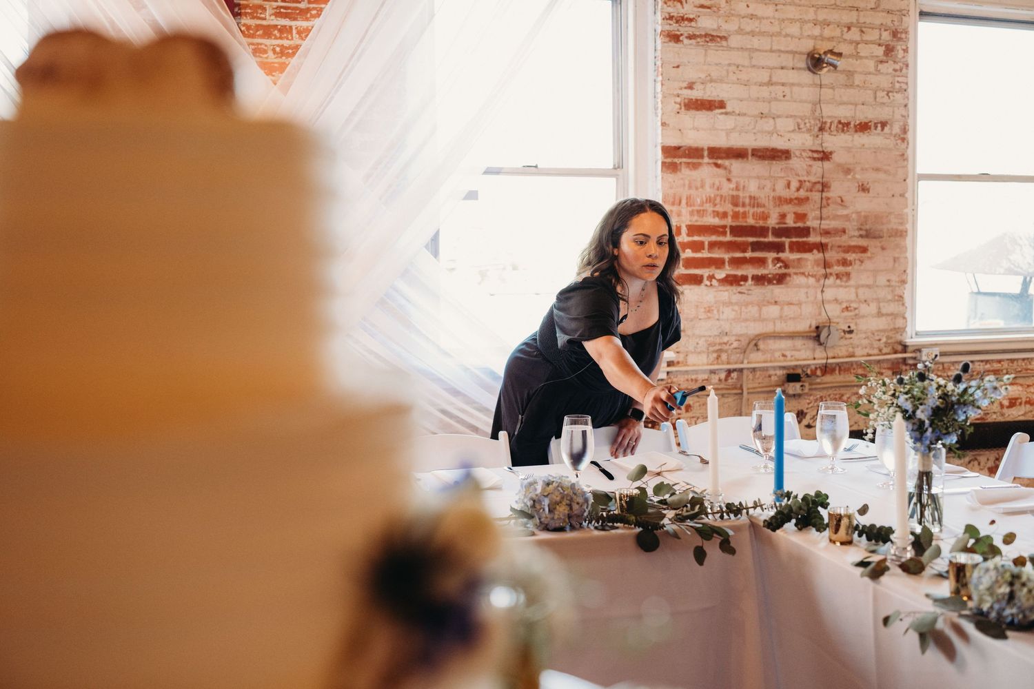 Wedding reception venue with exposed brick walls and elegant table settings.