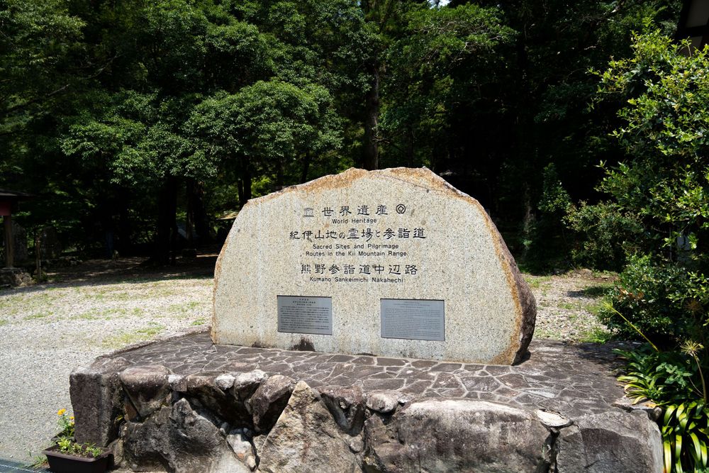 Stone monuments with Japanese inscriptions in a natural outdoor setting.