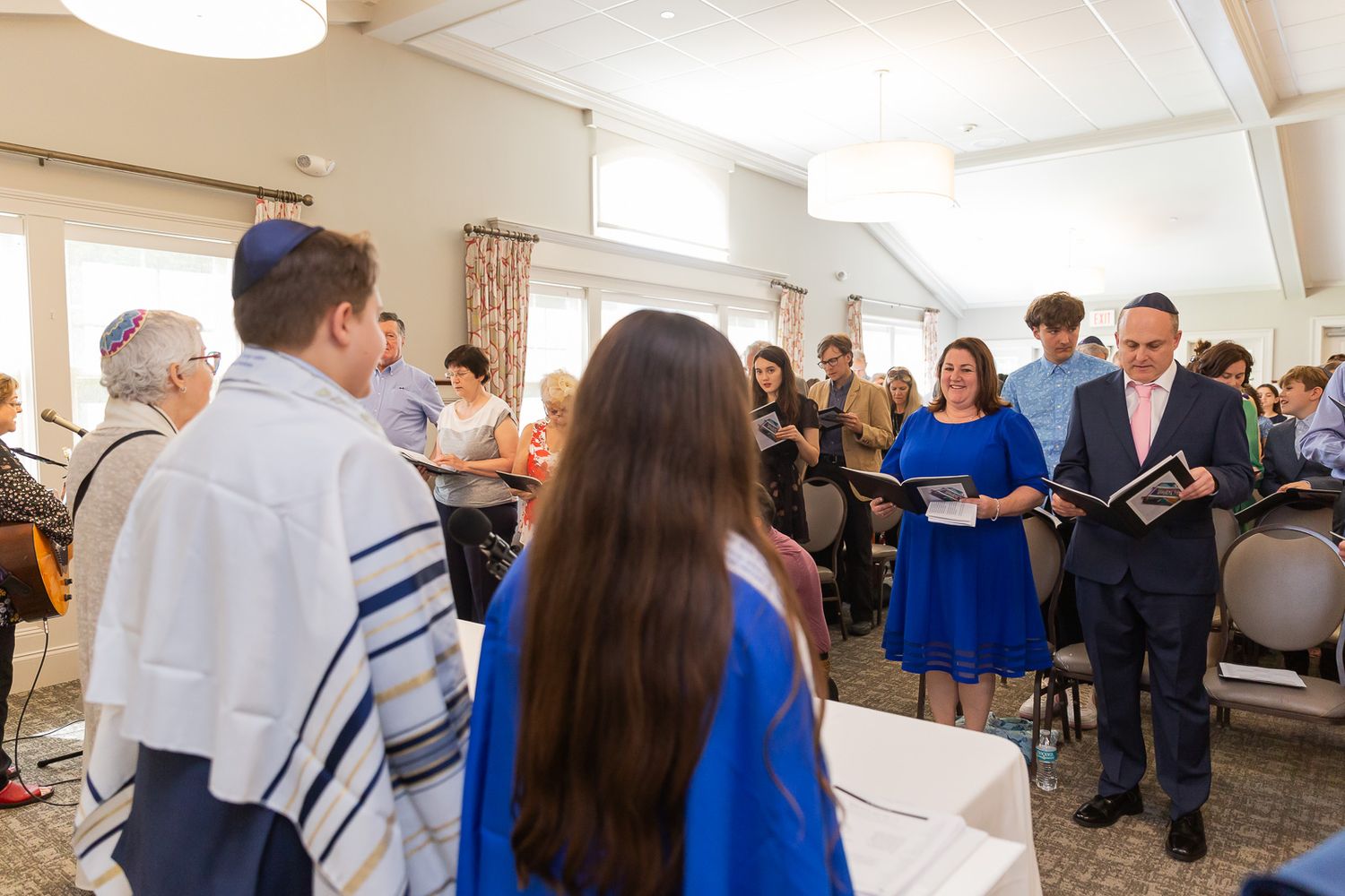 A congregation gathers in a bright room for a religious service.