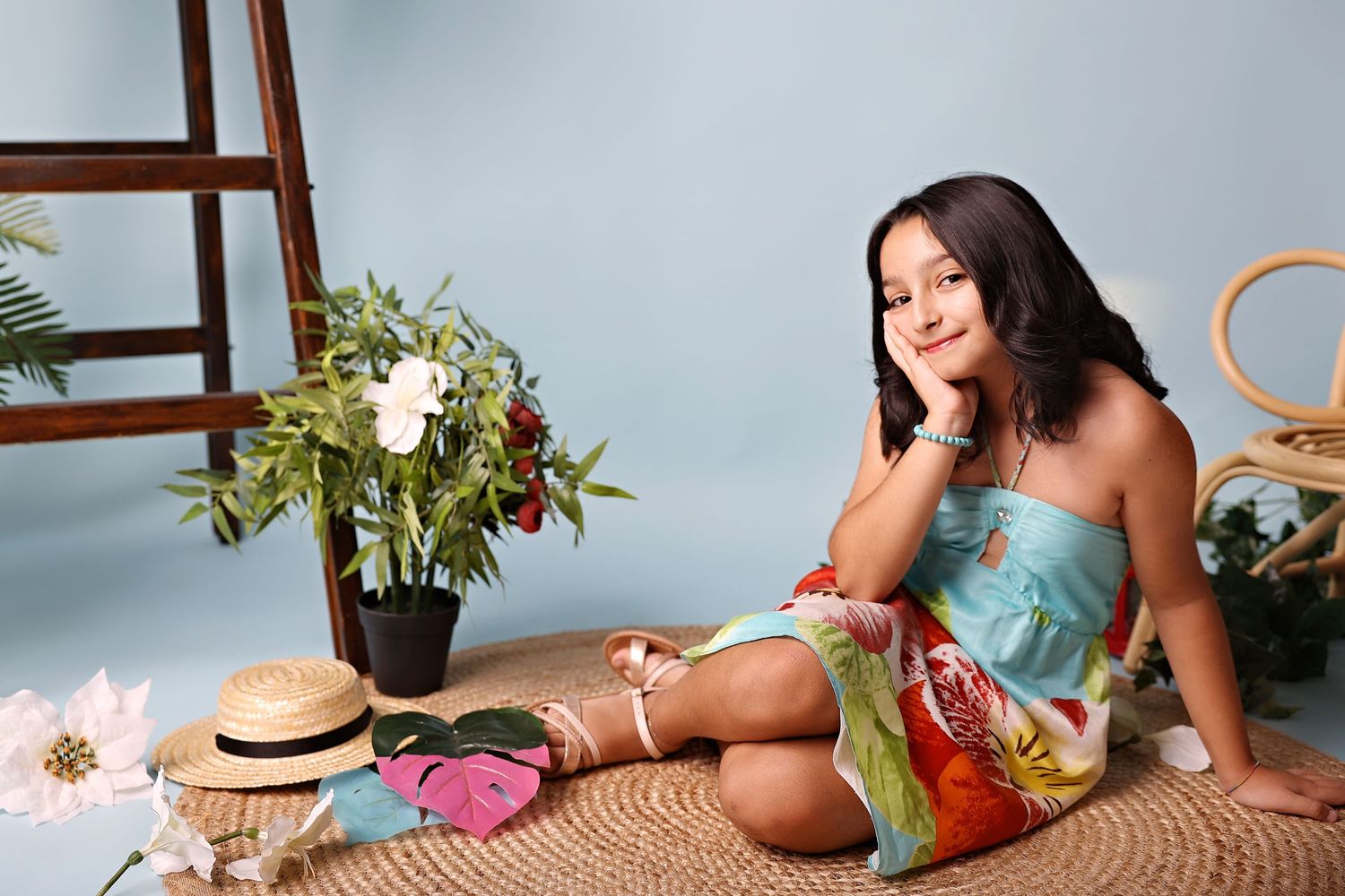 Casual lifestyle portrait with tropical decor and straw hat on woven mat.