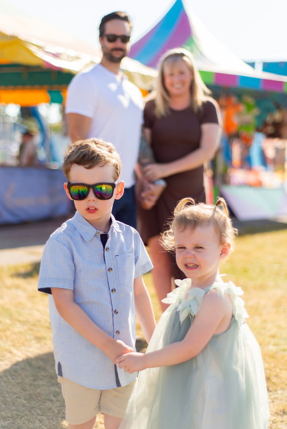 A sunny day at the carnival with children in coordinating outfits holding hands.