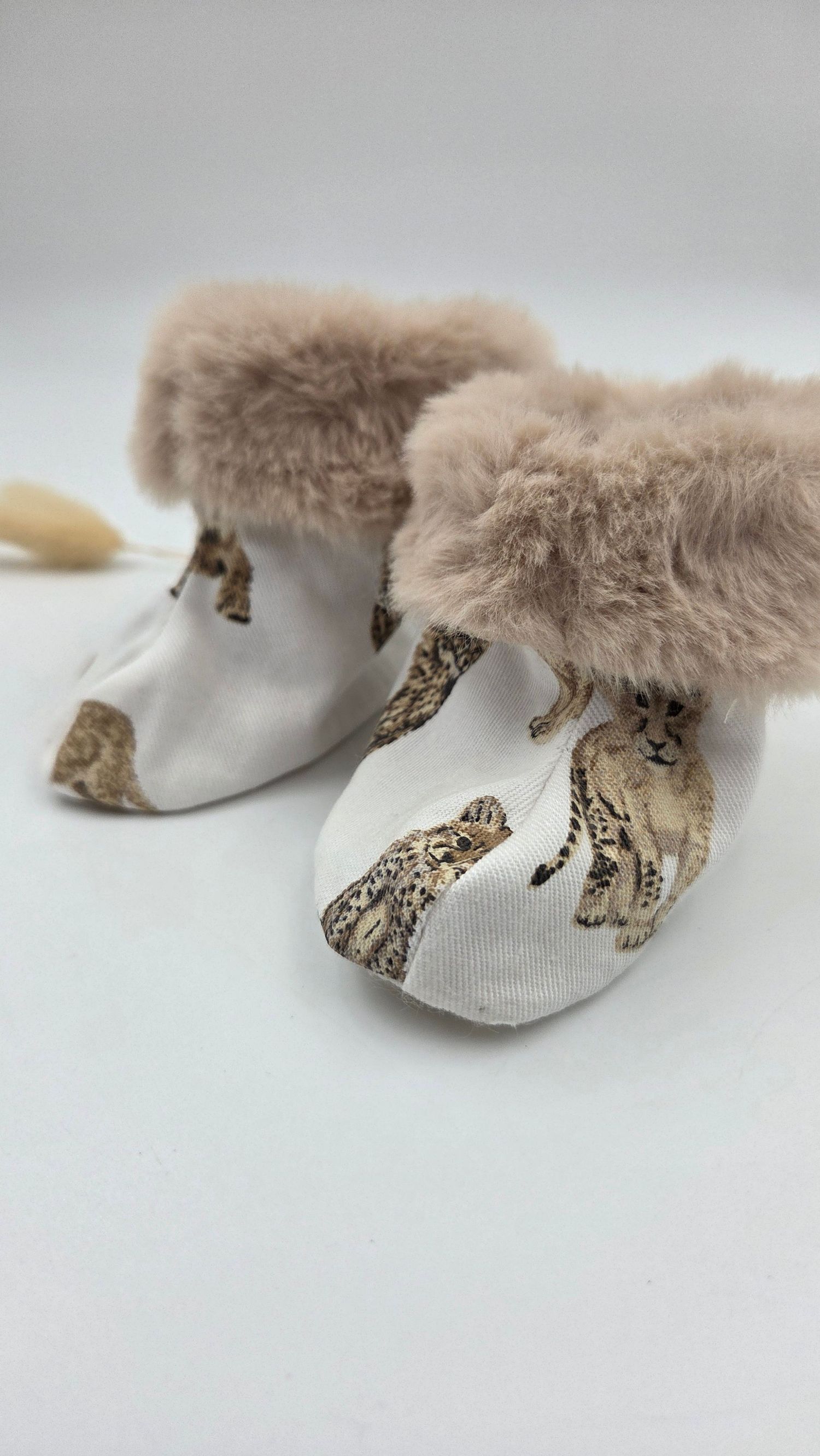 Adorable baby booties with cheetah print fabric and soft fluffy beige faux fur trim cuffs.
