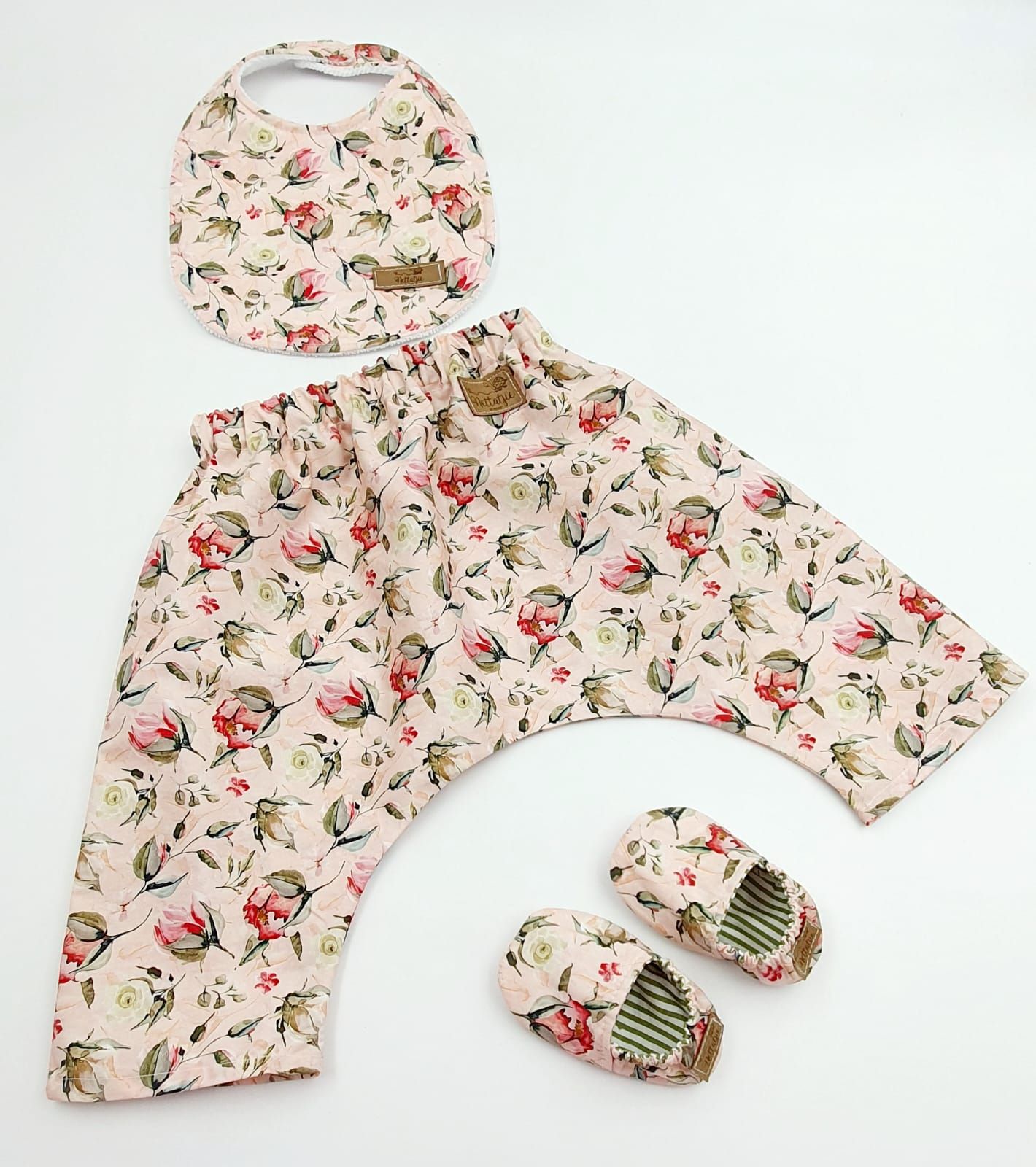 Floral print baby clothing set with matching shoes laid flat.
