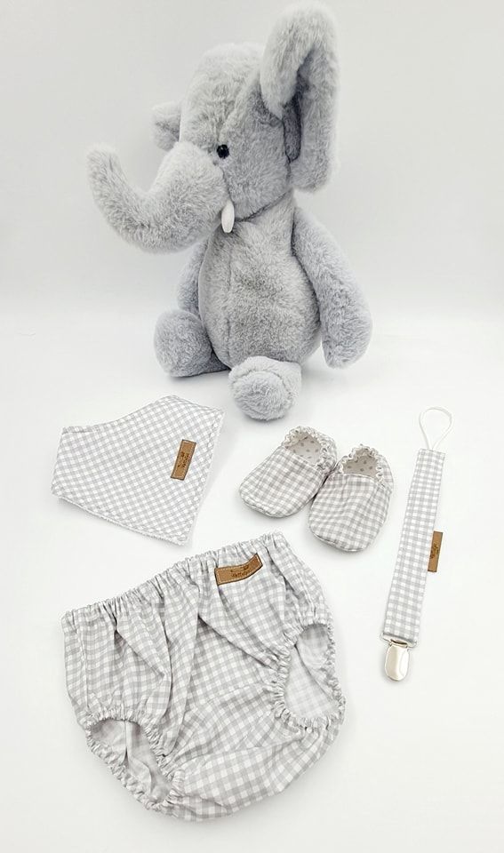 Gray checkered baby clothing set with matching accessories and plush elephant toy.