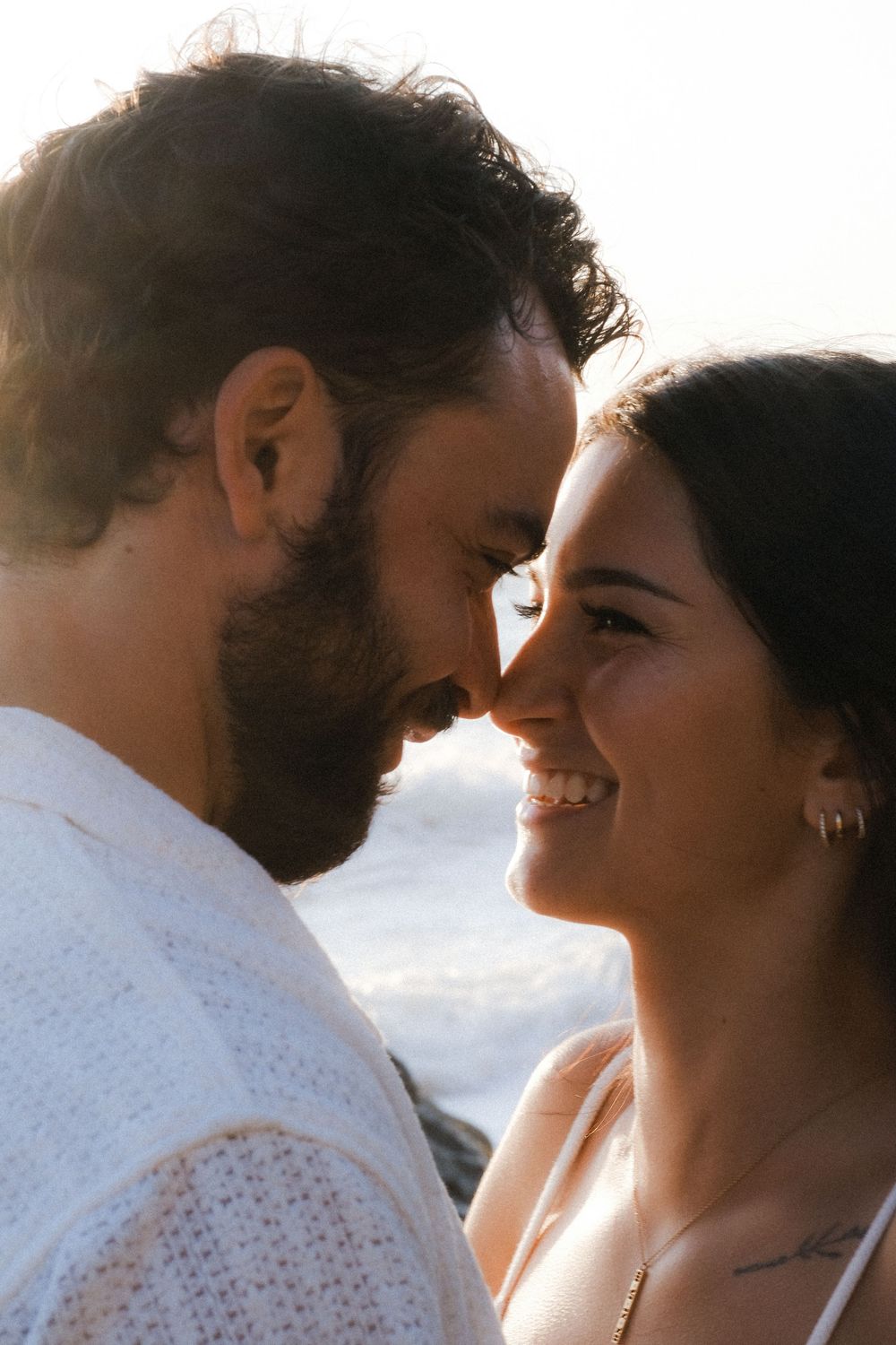 A romantic couple shares intimate moments in a series of backlit sunset portraits.