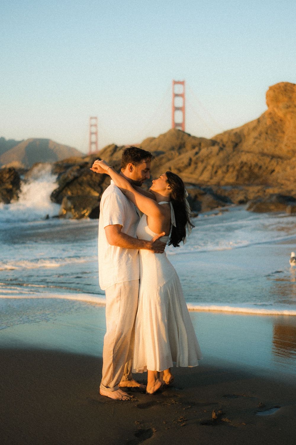 Dancing on Baker Beach with the iconic Golden Gate Bridge visible in the background.