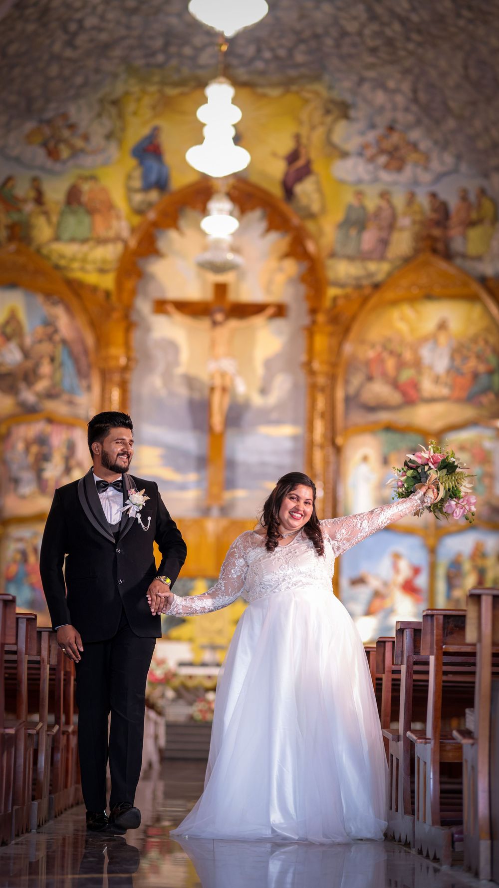 Bride and groom standing together inside a beautifully decorated church