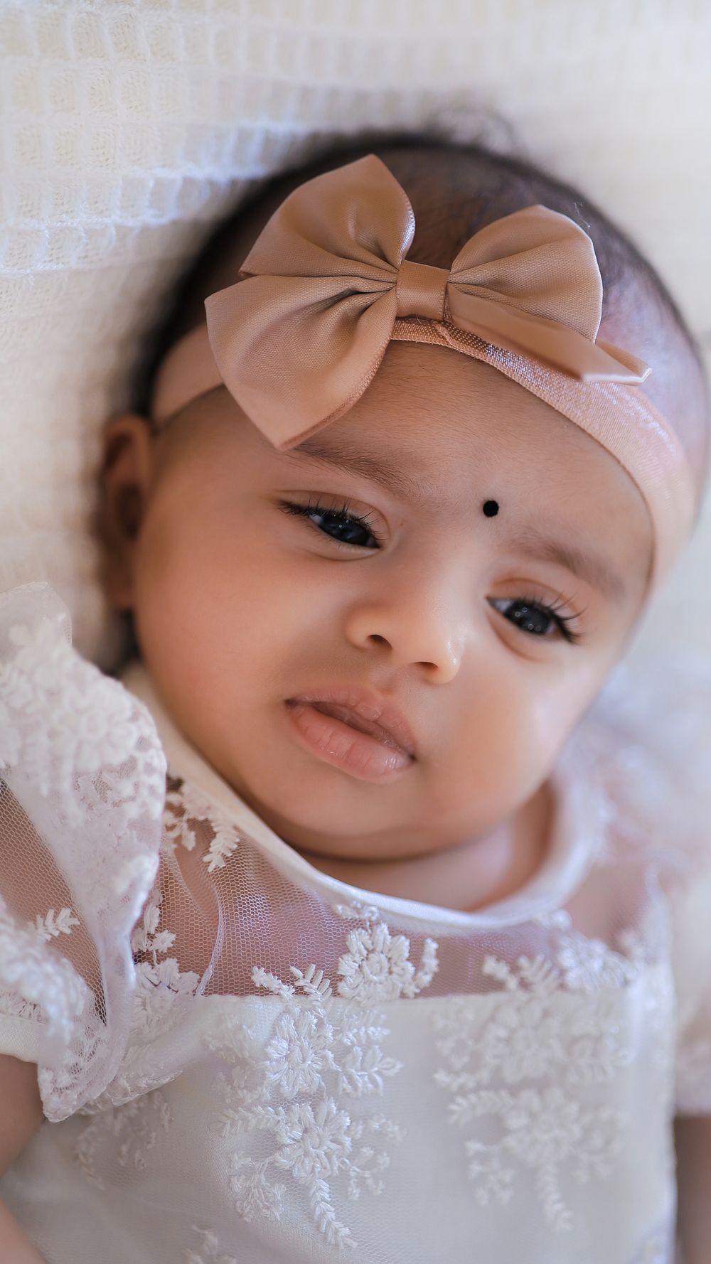 Baby wearing a headband photographed in a portrait session