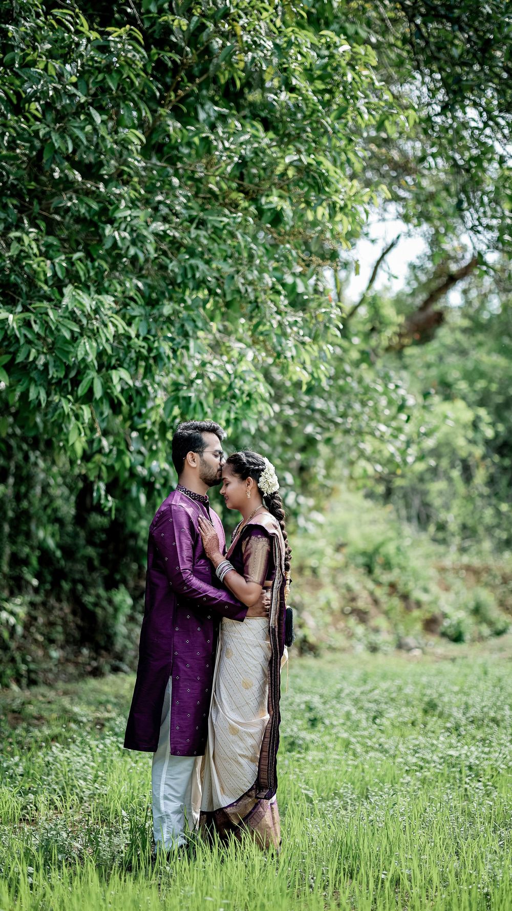 Couple embracing in a lush green outdoor setting