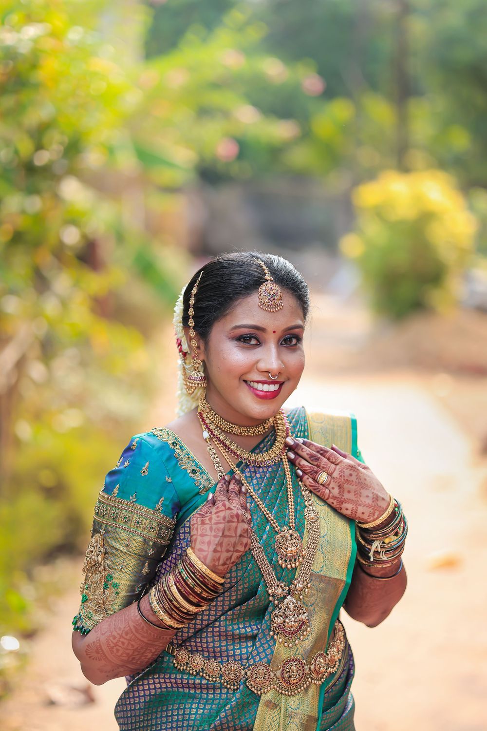 Bride wearing a traditional green sari and jewelry during a portrait session