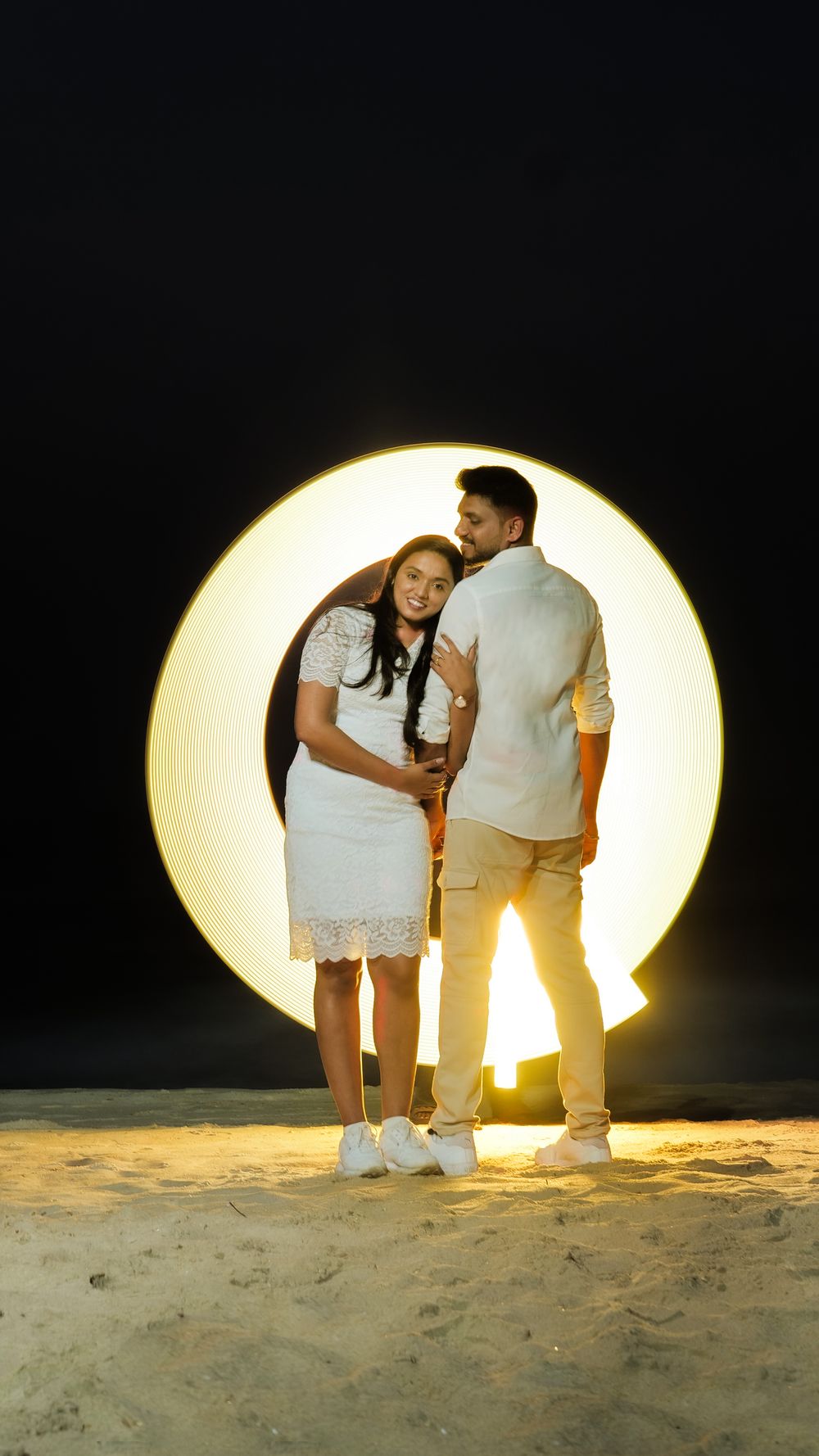 Couple standing together inside a glowing circular light during a creative photoshoot