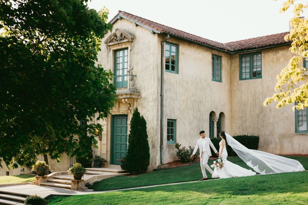 A series of connected exterior views of a Spanish Colonial style building with white stucco walls and terracotta roof tiles.