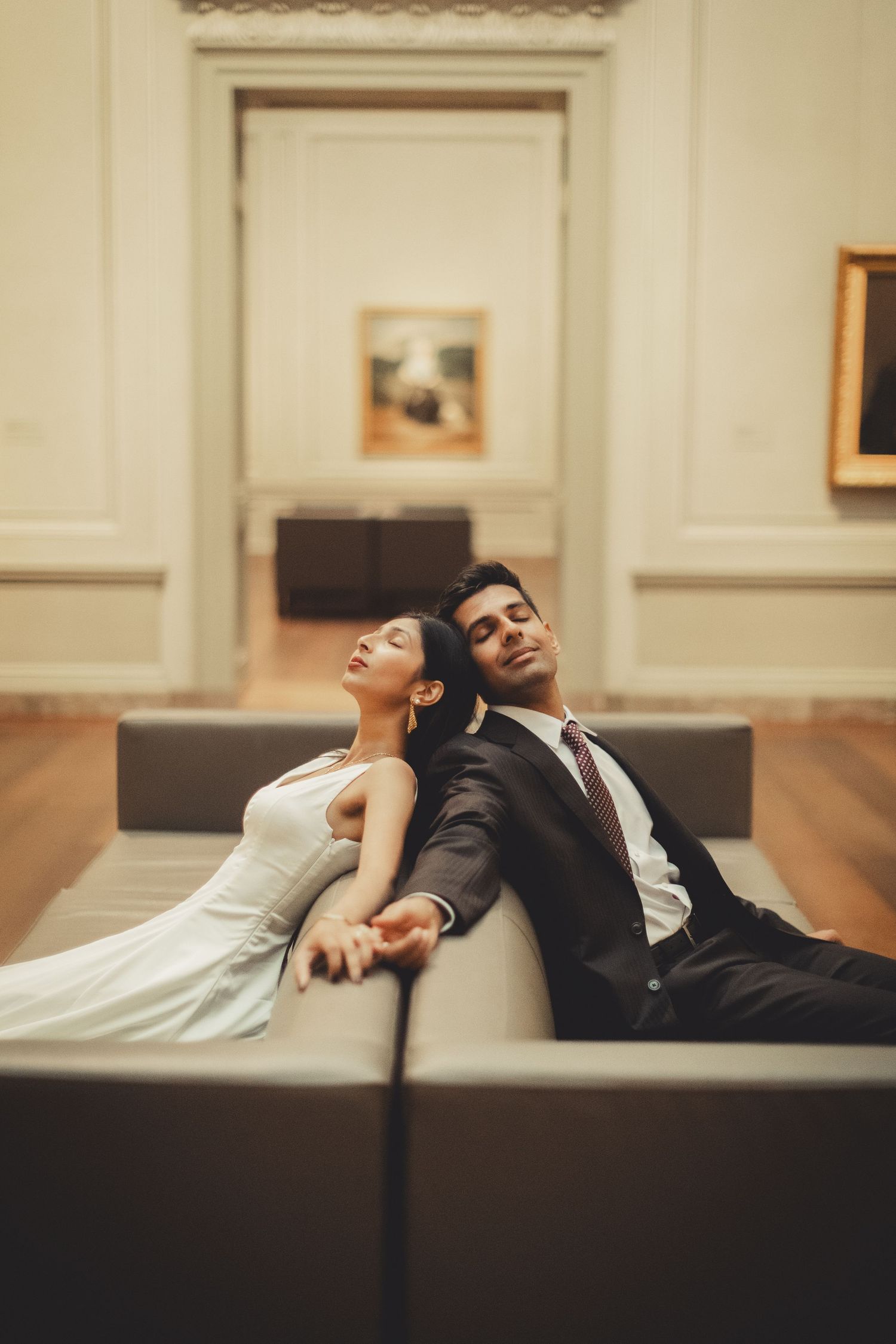 Romantic couple reclines on couches in the national gallery of art