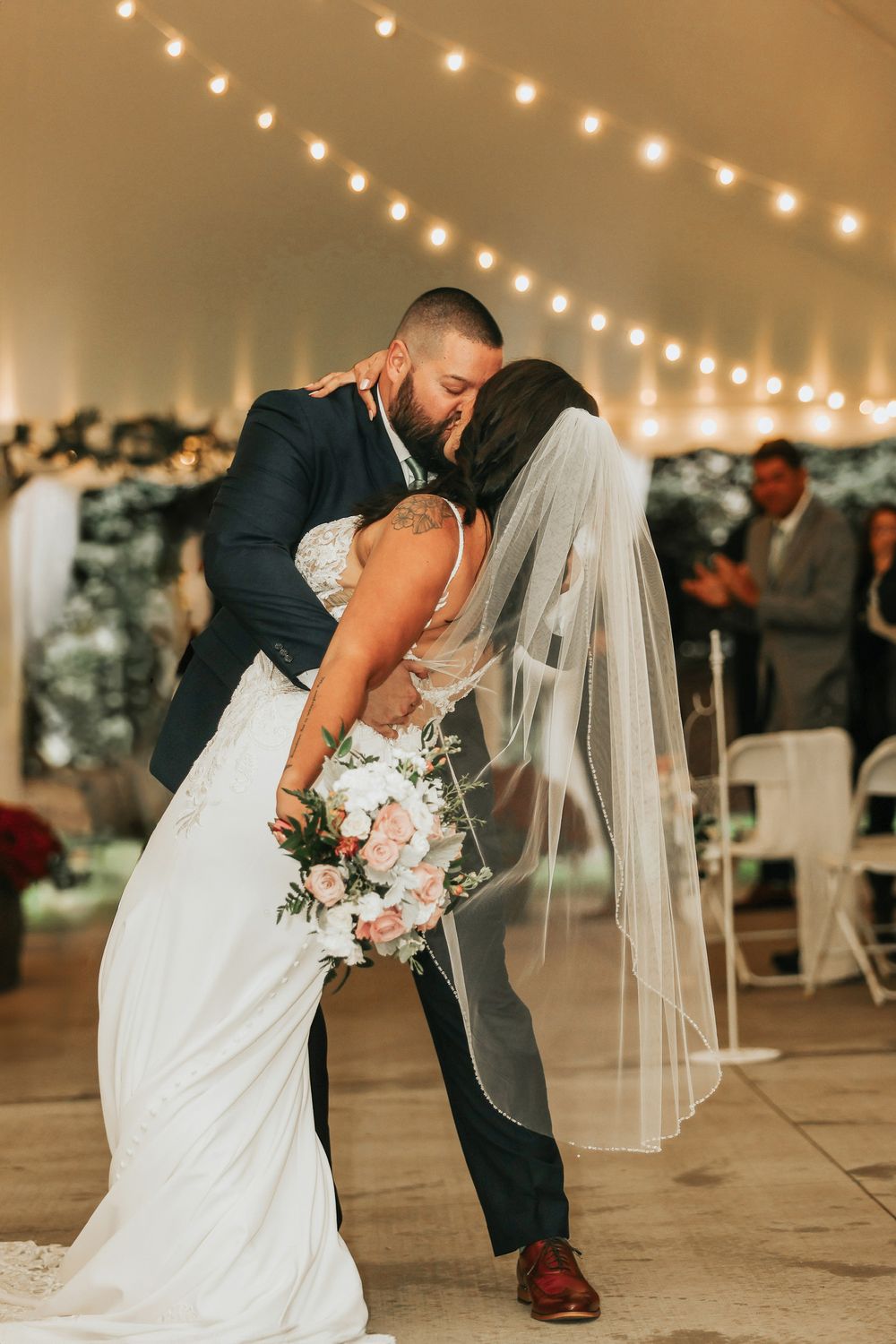 A romantic wedding dance sequence under twinkling lights in an outdoor tent venue.