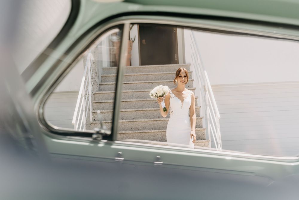 Vintage car frames view of figure in white dress on staircase.