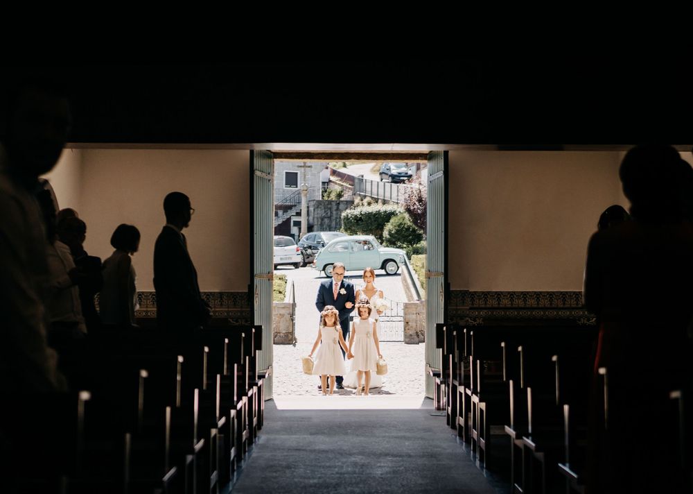 Silhouetted church interior with couple entering through bright doorway.
