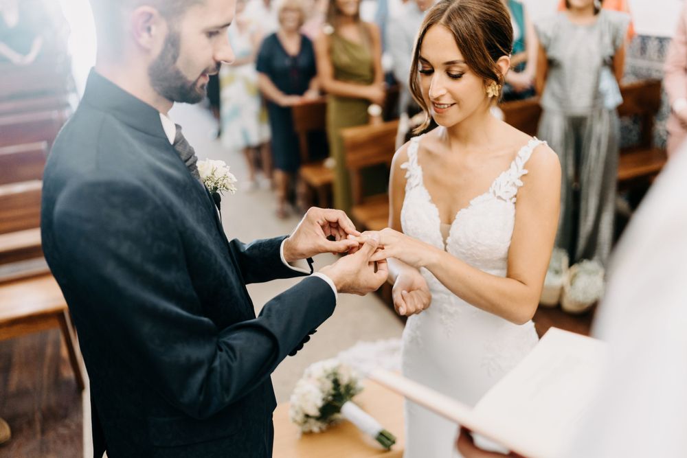 A couple exchanges rings during an intimate indoor wedding ceremony.