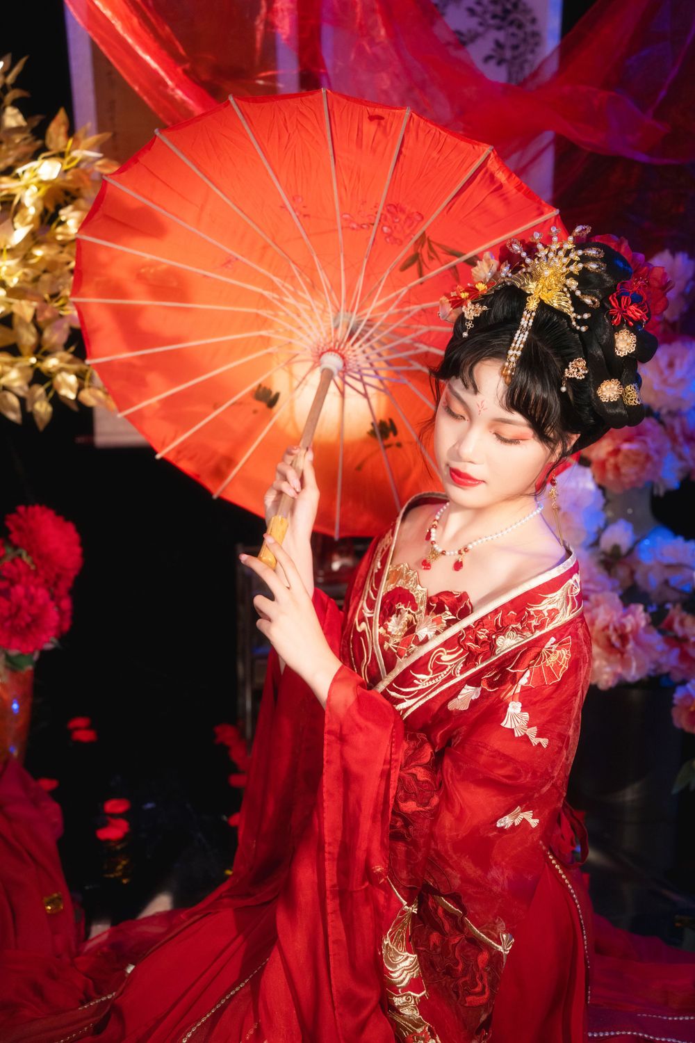 Sensual and serene red-toned Hanfu studio portrait among spider lilies and glowing candles, by Imagine Image Studio.