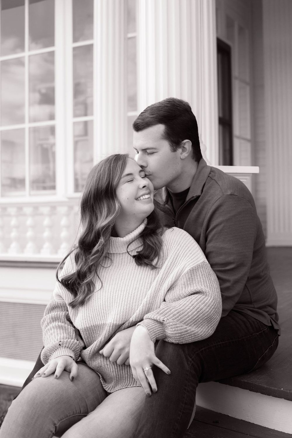 A romantic black and white photo series of a couple sharing intimate moments on a porch.