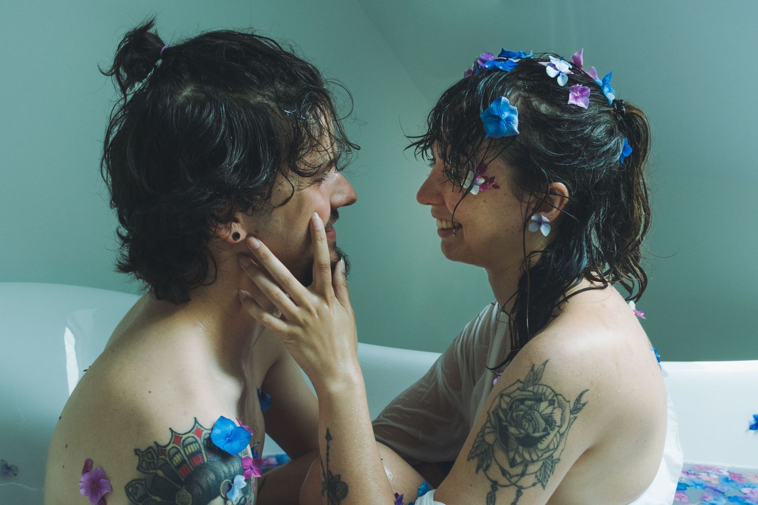 Photographie d'un couple d'un homme et une femme qui se regarde tendrement dans une baignoire