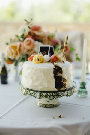 Slice of white frosted wedding cake displayed on ornate vintage-style serving plate with delicate lace trim details.