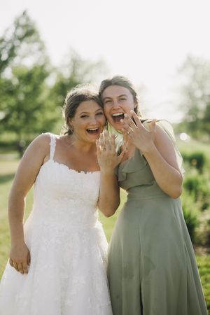 Two high spirited individuals share laughter and joyful expressions in outdoor wedding attire.