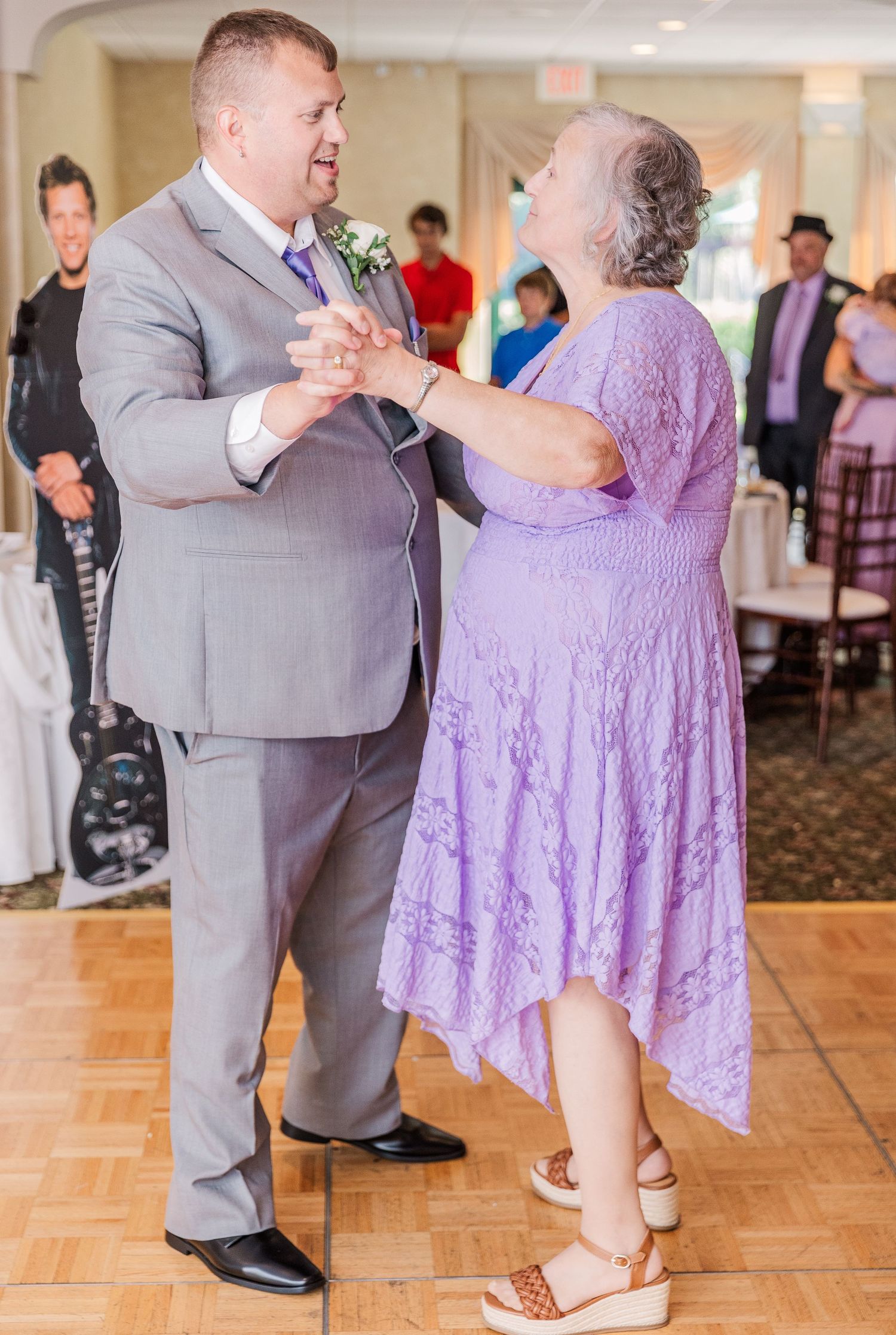A couple shares a dance in formal attire at a wedding reception.