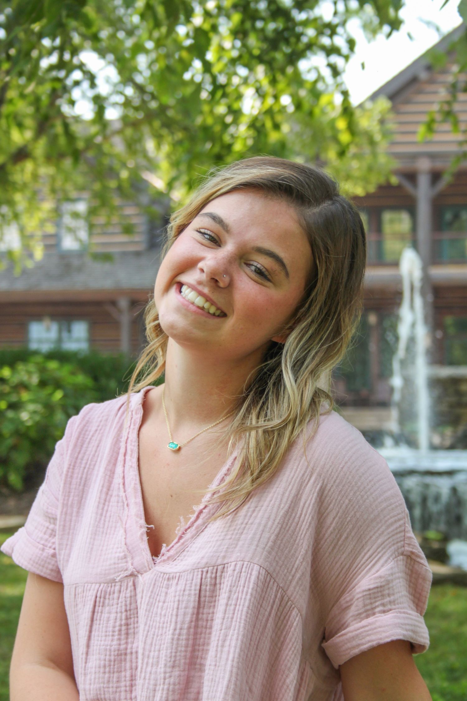 Girl smiling at college of the ozarks for senior pictures.