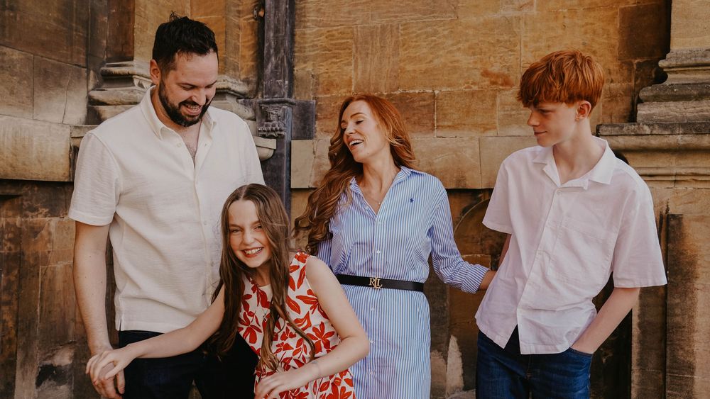 Candid outdoor family photoshoot with warm lighting and natural greenery in the background.