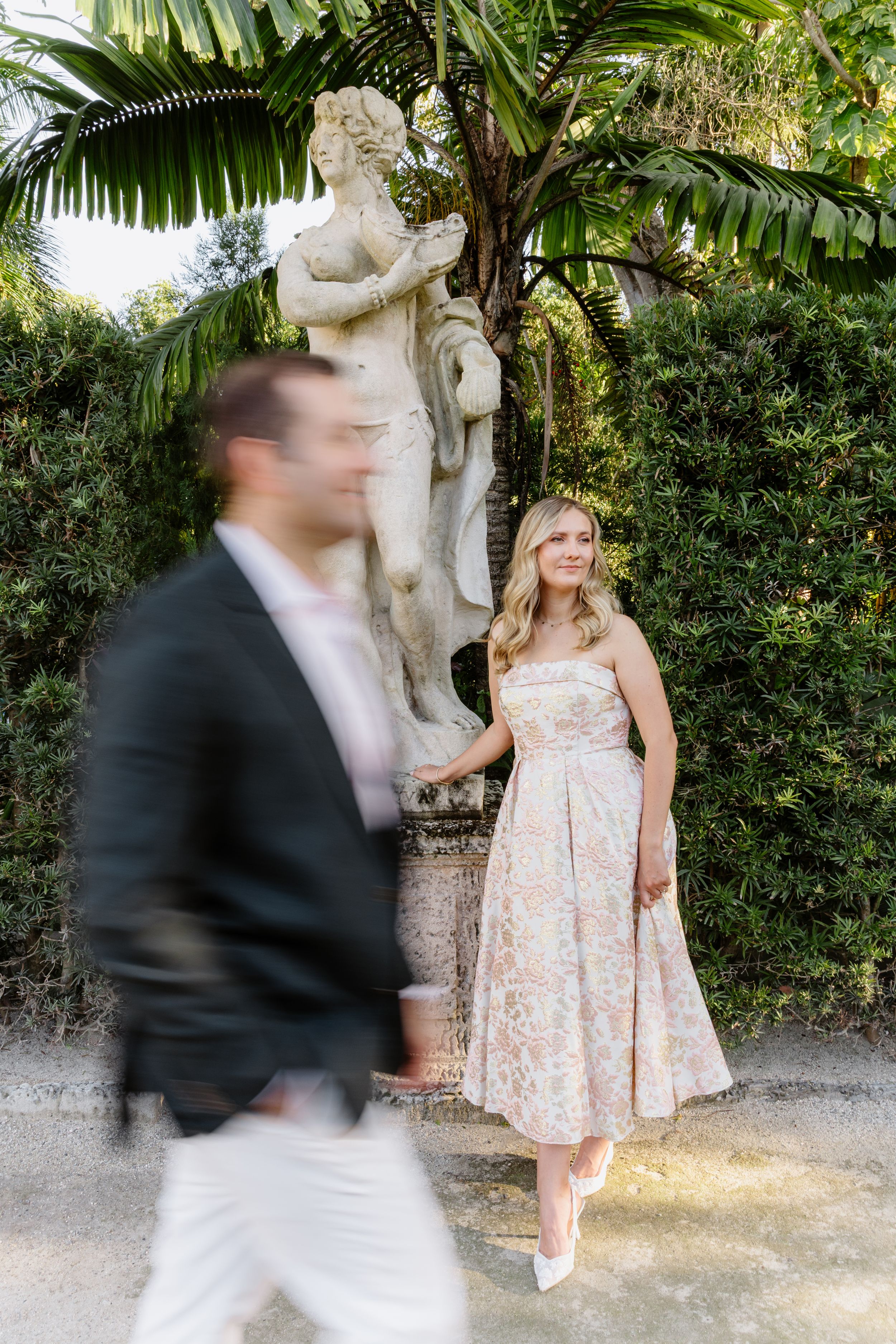 A sequence of motion blur photos showing a couple posing near tropical plants and a garden statue.