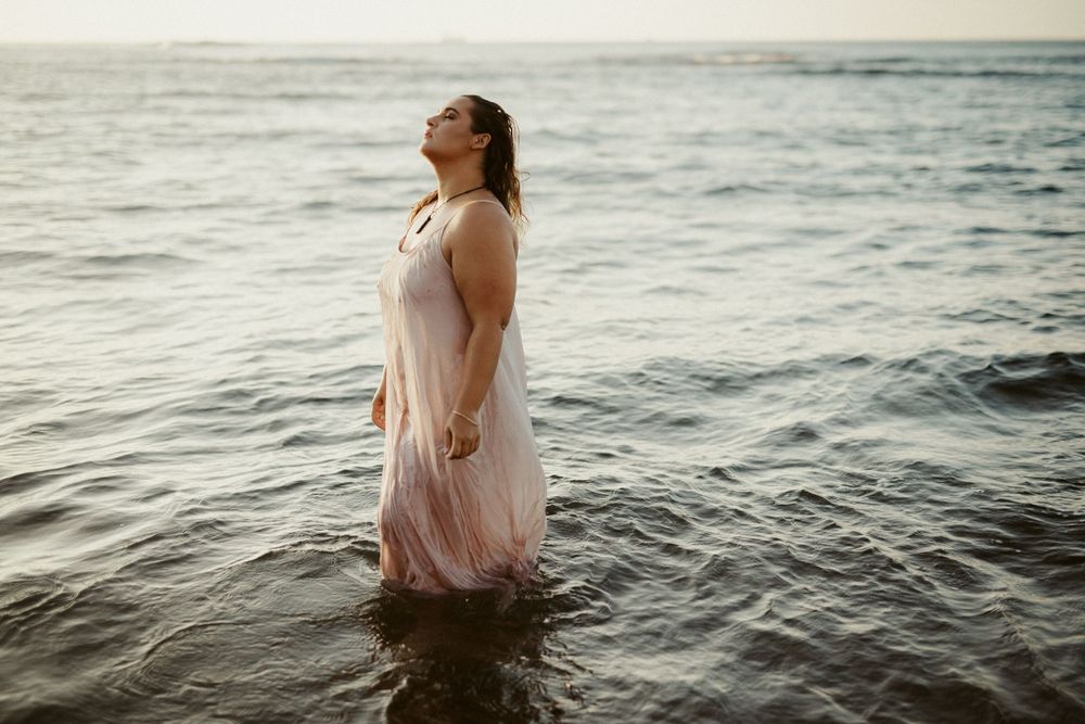 dramatic photo of woman in sunrise ocean water