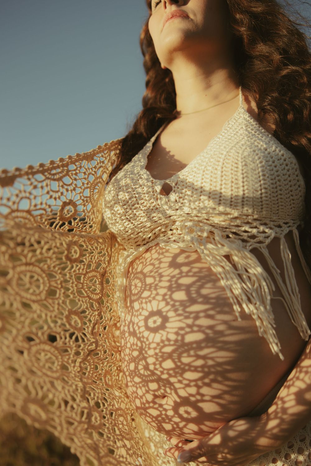 Close-up detail shots of intricate white crochet lace pattern in warm sunlight.