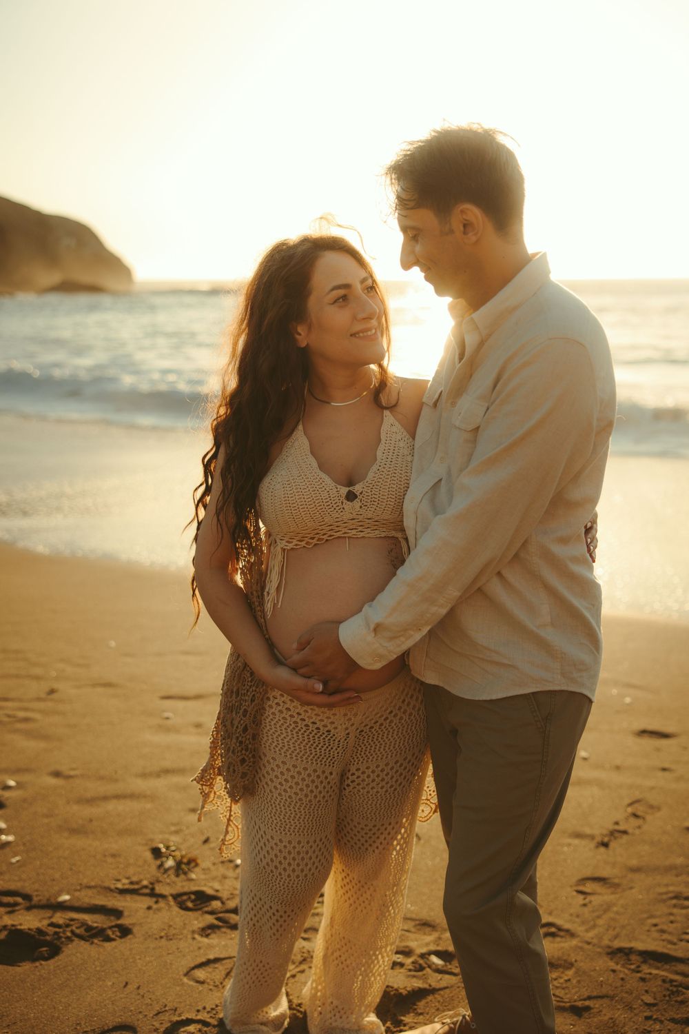 Intimate beach photoshoot at golden hour with couple in romantic poses.