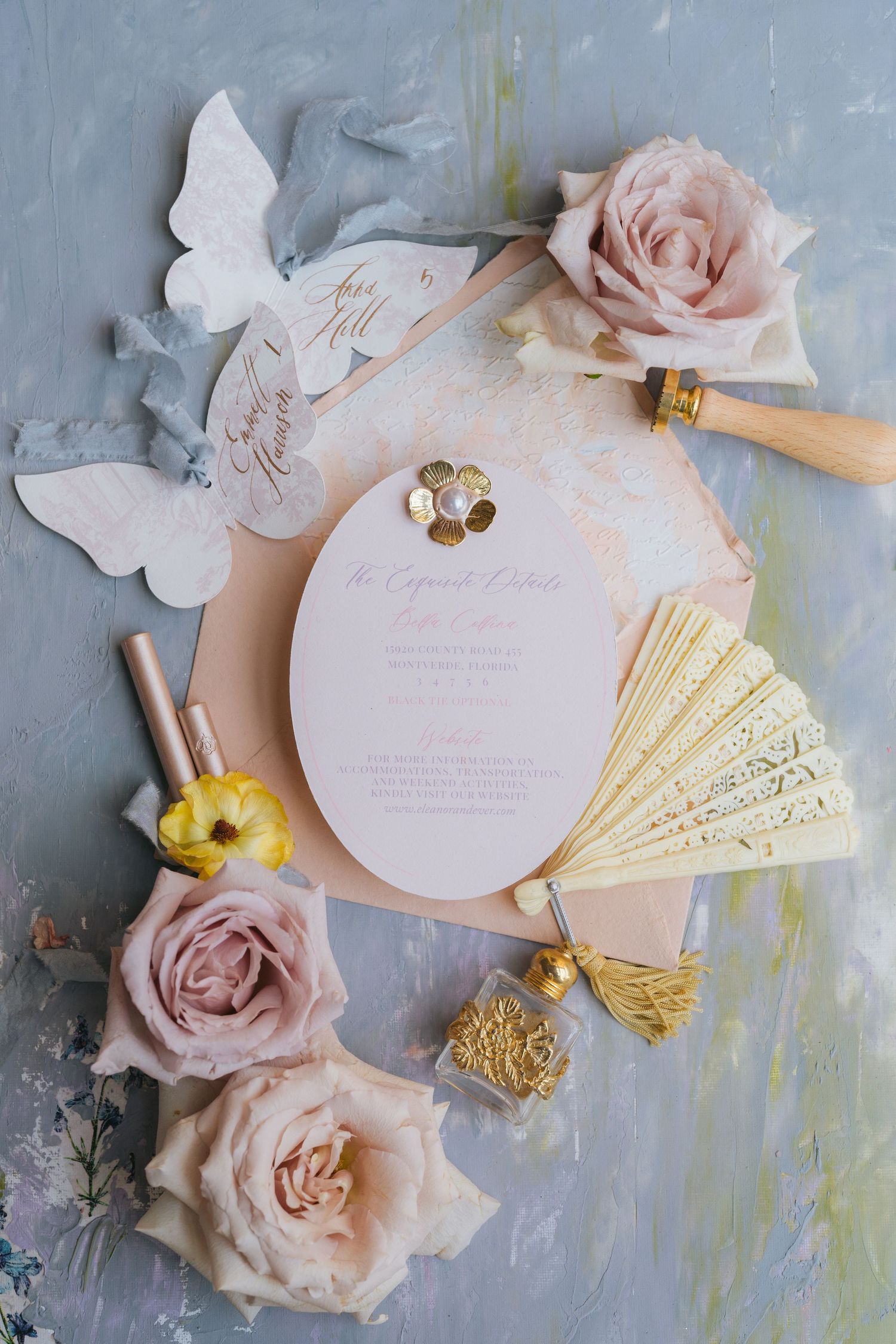 Wedding stationery flatlay with gold details and blush pink roses.