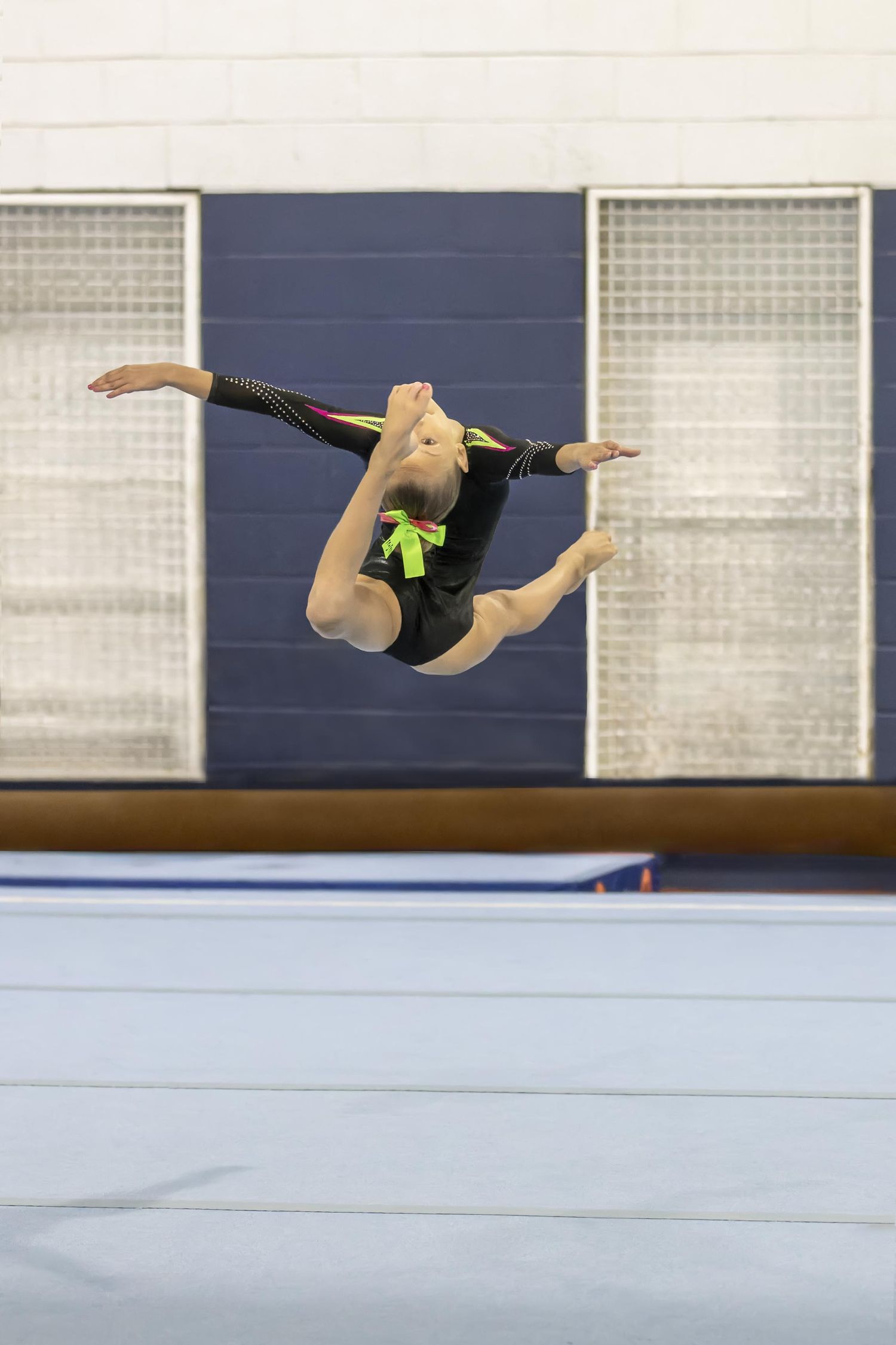 Nick Wigmore Photography captures young girl executing gymnastics jump.