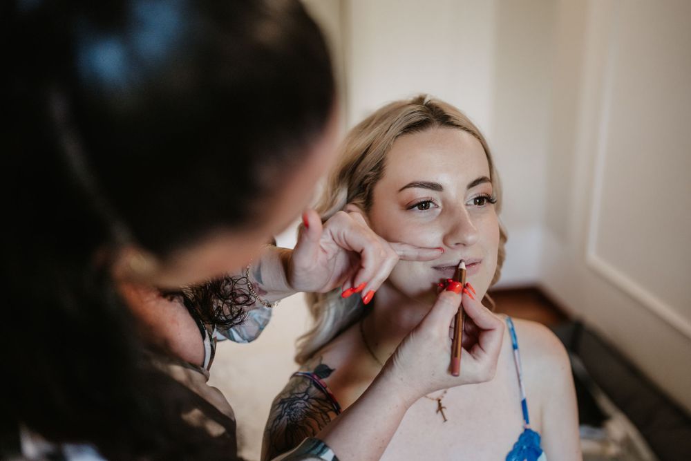 Close-up of makeup application process with artistic tattoo details.