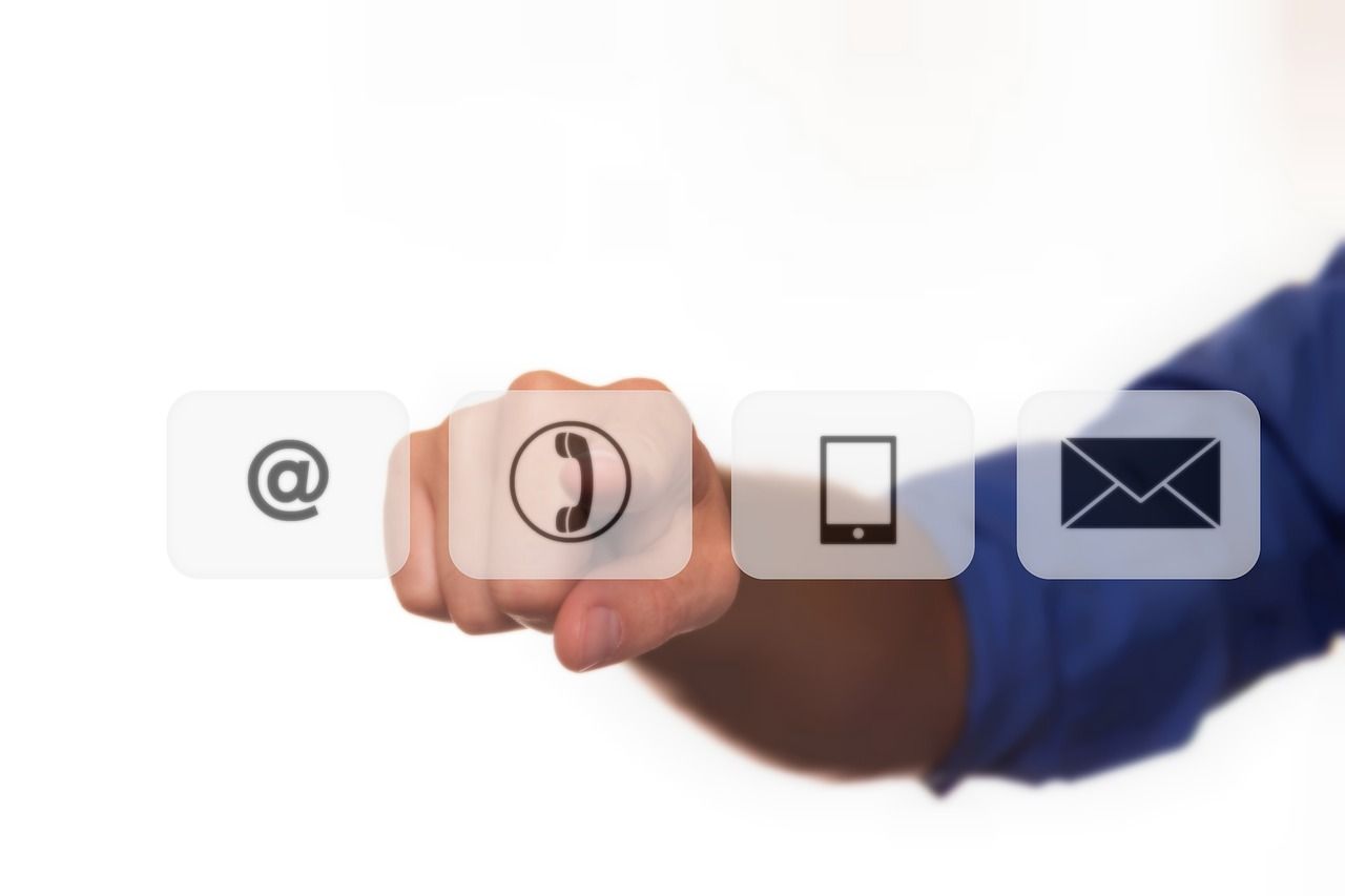 A row of white icons showing phone, mobile device and email communication symbols against a dark background.