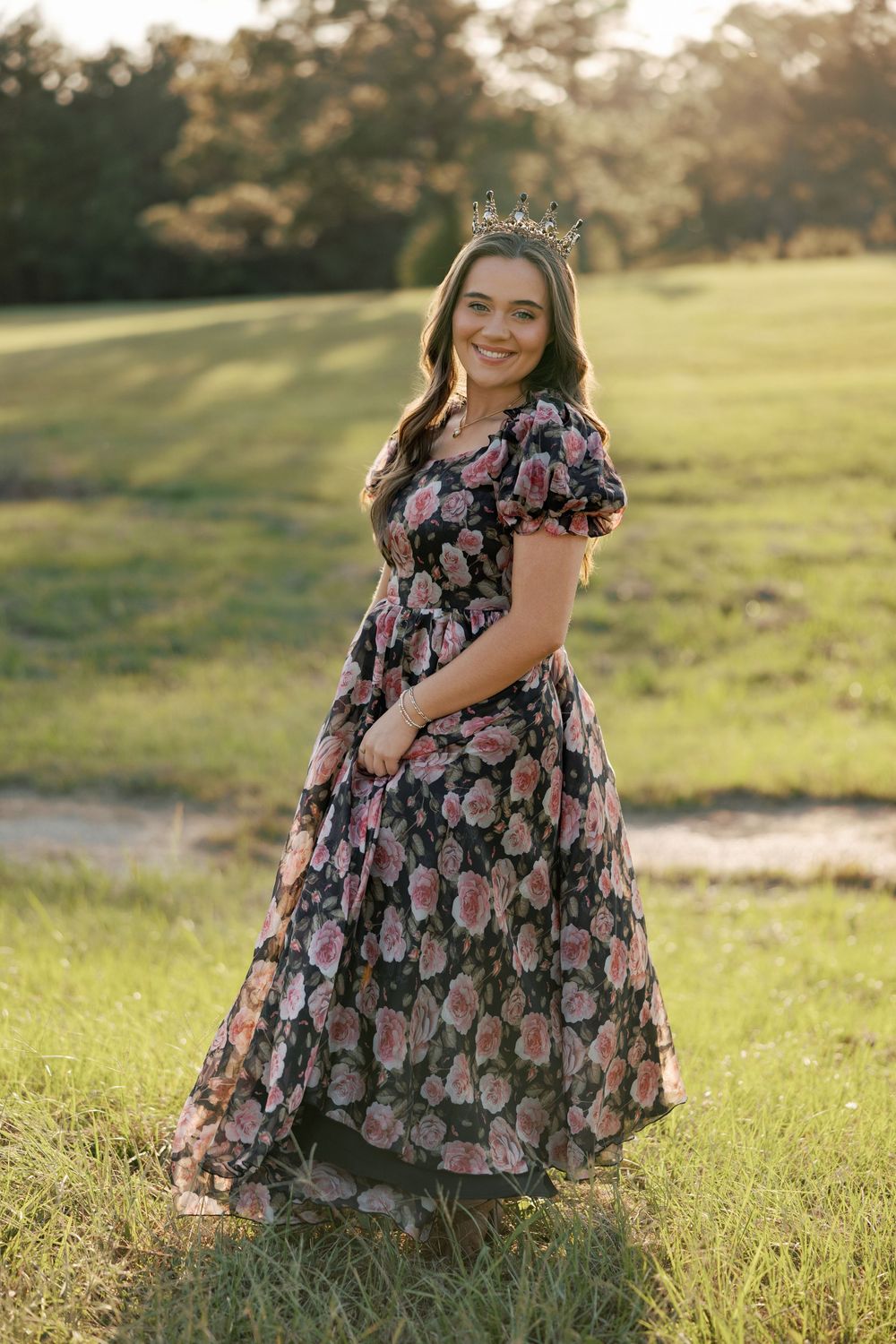 A floral dress flows gracefully in a sunlit meadow during golden hour as someone poses in nature.