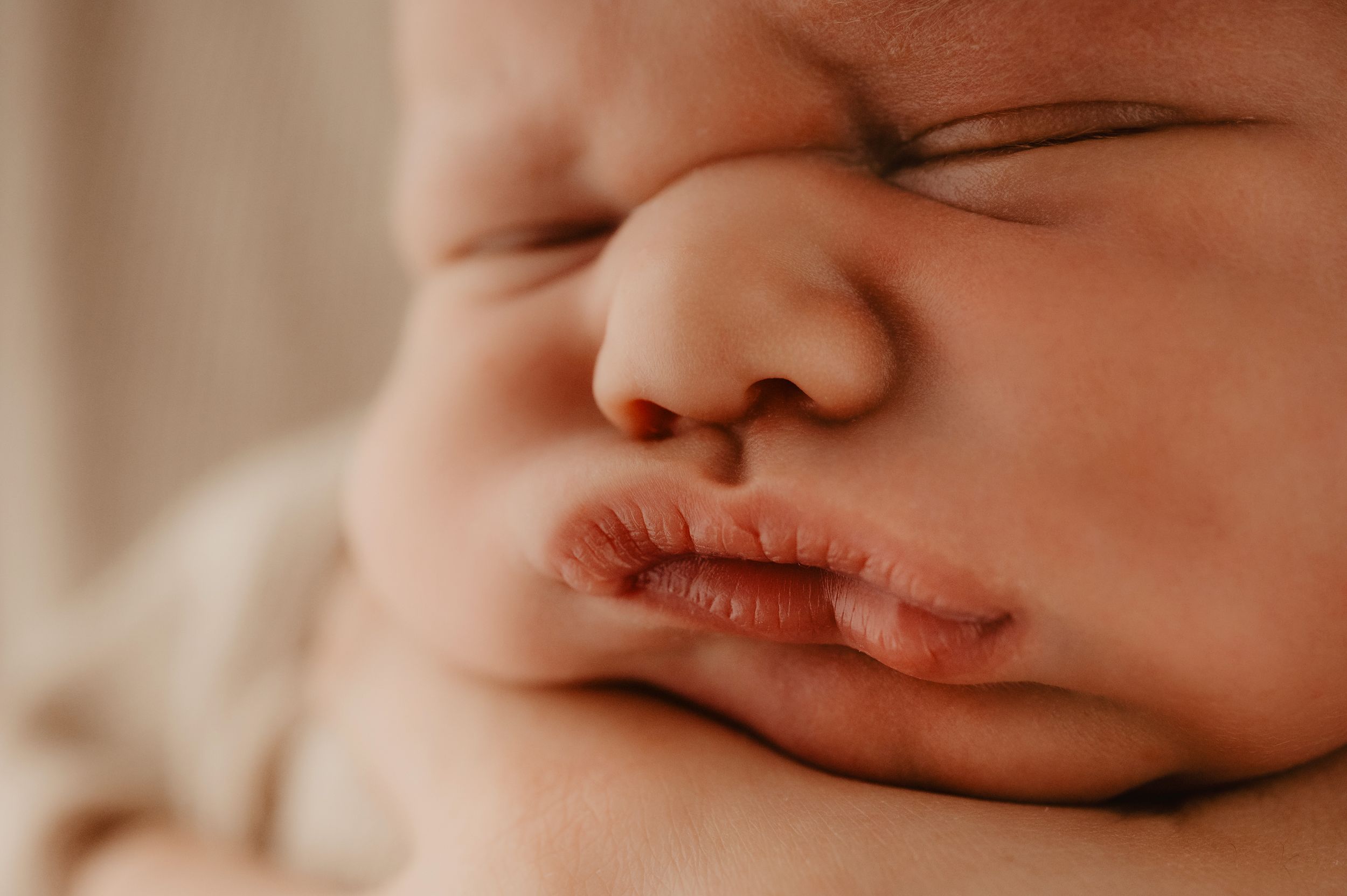 Extreme close up of baby's nose and lips in soft natural lighting.