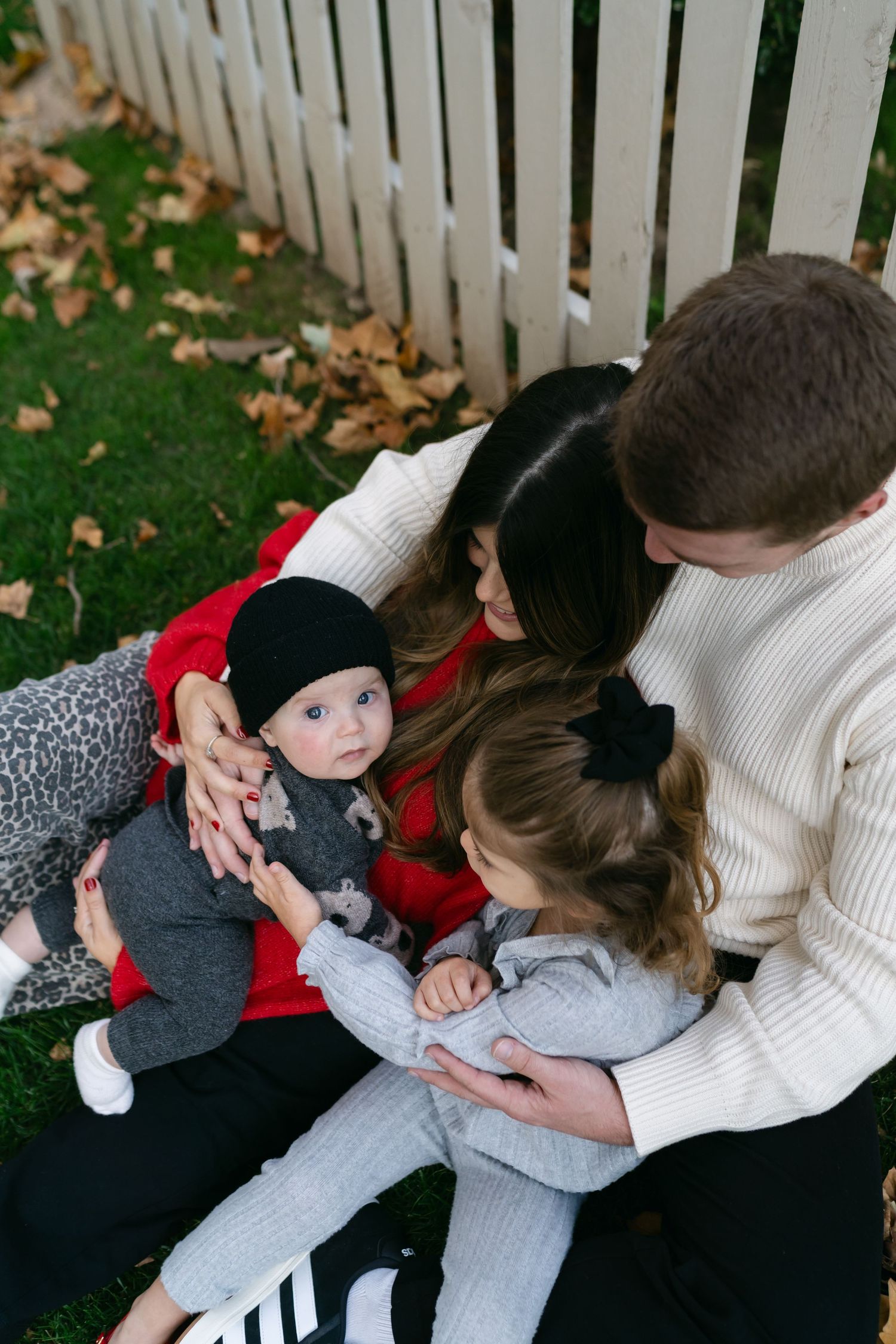 Family sharing tender moments while cuddling on a cozy blanket outdoors.