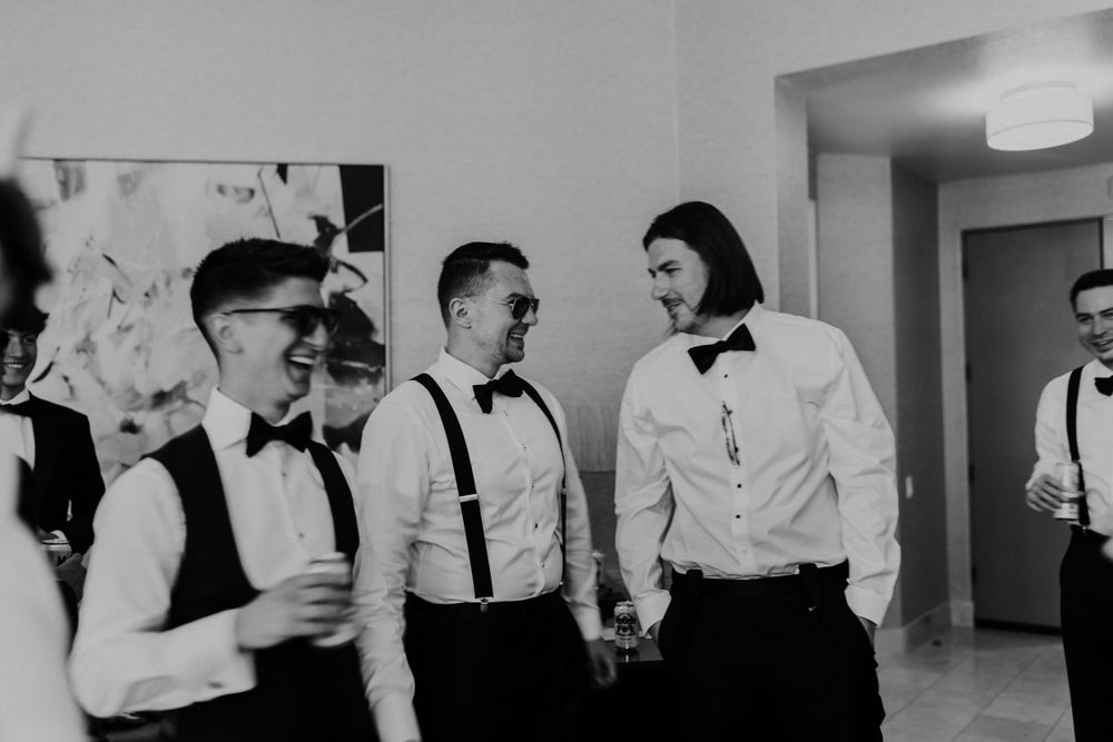 Groomsmen in formal attire gathering before wedding ceremony.
