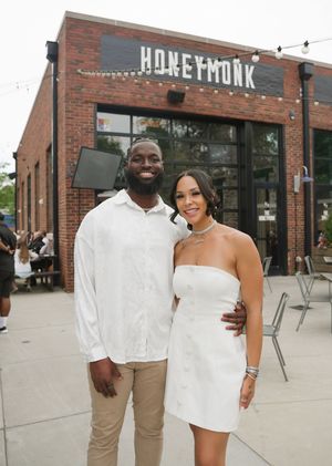 People pose together outside a brick building with 'Hopefmunk' signage.