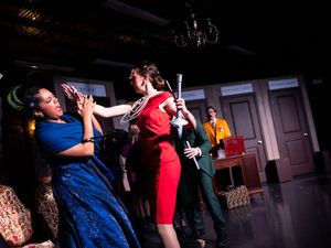 Couples dancing together in a dimly lit ballroom during a formal evening event.