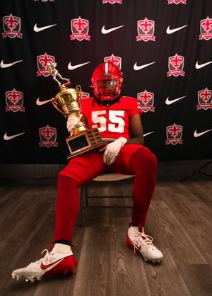 A series of four photos showing a football player in red uniform posing with a golden trophy on a dark backdrop.