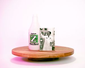 A white glass milk bottle and glass on a wooden circular platform with pink background lighting.