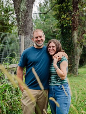 Natural outdoor family portraits showing genuine laughter and connection among loved ones in a garden setting.
