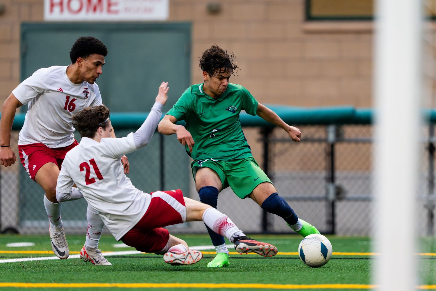 A sliding tackle attempt during a men's soccer match featuring Woodinville High School.
