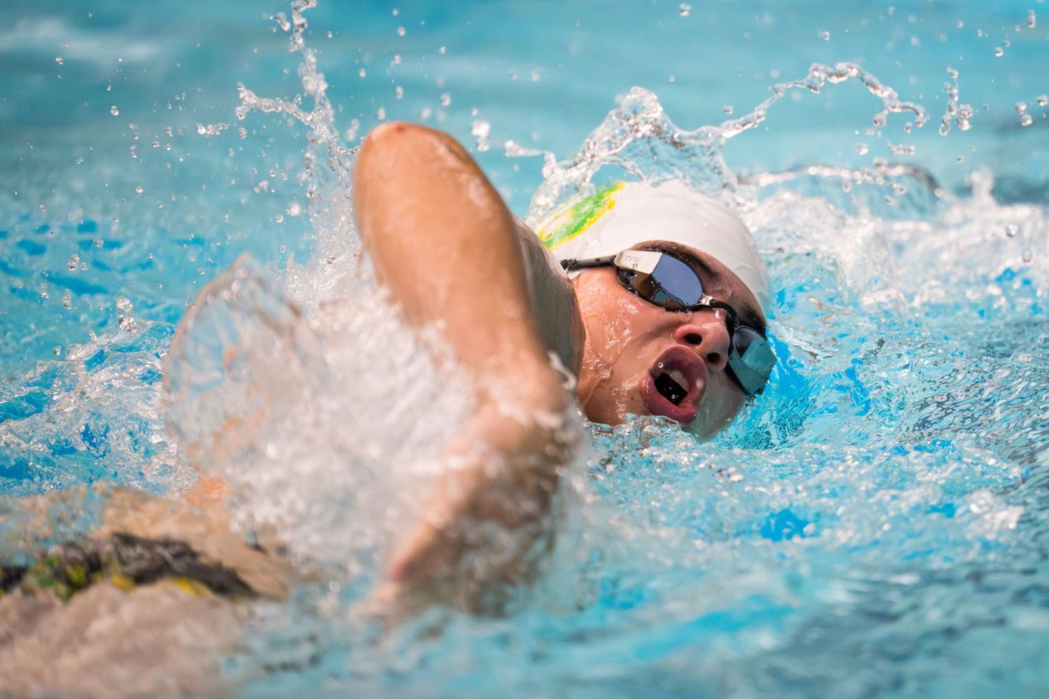 A swimmer from Bishop Blanchet High School is mid stroke during a freestyle competition.