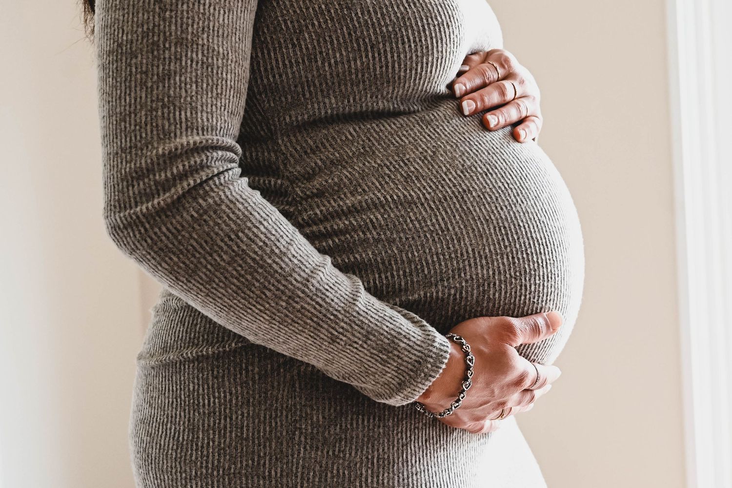 Natural light lifestyle maternity portrait session with mom holding her belly
